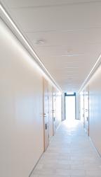 Upeasti pitkillä LED-nauhoilla valaistu kerrostalon käytävä