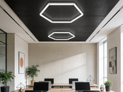 Kaksi Hexagon HEXO 1-GRID LED-valaisinta asennettuna mustaan toimistotilan kattoon neuvotteluhuoneessa