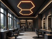 Hexagon HEXO 2-GRID LED-valosarja asennettuna parturin kattoon, kaksi kuusikulmion muotoista LED-kehyst&auml; hehkuvat l&auml;mpim&auml;ll&auml; valolla tummassa tilassa