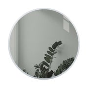 Py&ouml;re&auml; valkoinen sein&auml;peili T&Auml;HK&Auml; heijastelee huonetta ja vihre&auml;&auml; kasvia, halkaisija 800 mm