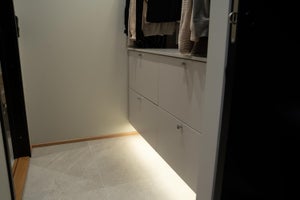 Epäsuoraa valoa kaapiston alla vaatehuoneessa. LED-nauha on helppo asentaa sokkeliin myös ilman profiilia. Yhdistä nauhaan liiketunnistin ja valot ovat aina oikeaan päällä!