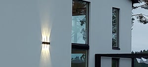 Tyylikkäästi kolme valaisinta vierekkäin julkisivun ja seinän valona.