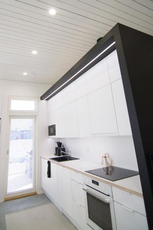 Keittiön yleisvalona OODI valaisimet. LED-nauha on upotettu keittiön lippaan upotettavan profiilin avulla. Myös työtason valaistukseen on käytetty LED-nauhaa.